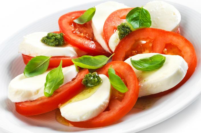 An appetizing caprese salad with fresh tomatoes, mozzarella and basil. 