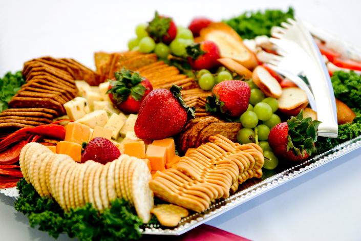 Cheese and cracker platter paired with fresh strawberries and grapes.